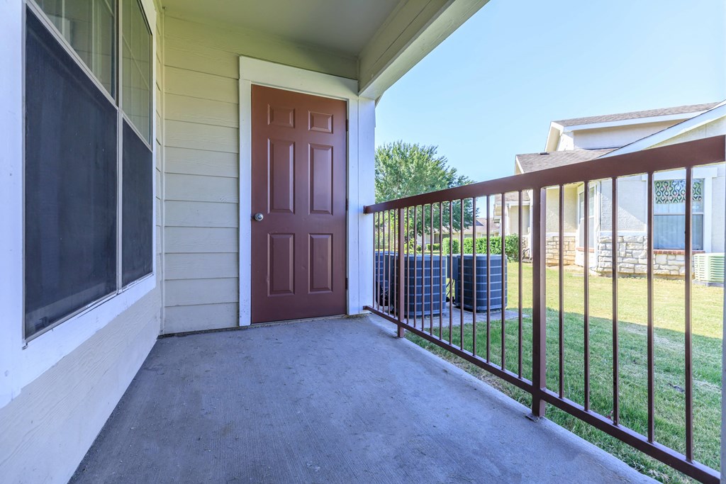 the entrance to a house with a porch and a brown door