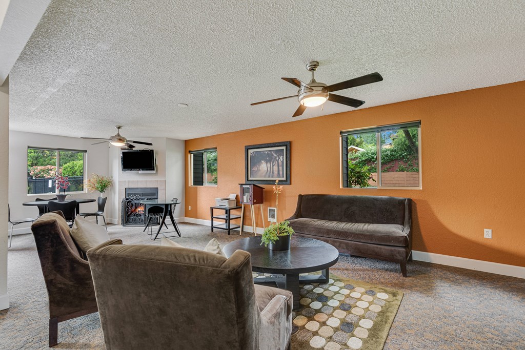 a living room with couches and a table and a ceiling fan at Eagles Landing Apartments, Everett, WA