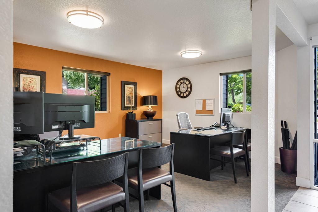 a dining room with a glass table and chairs and a desk with a computer at Eagles Landing Apartments, Everett, WA