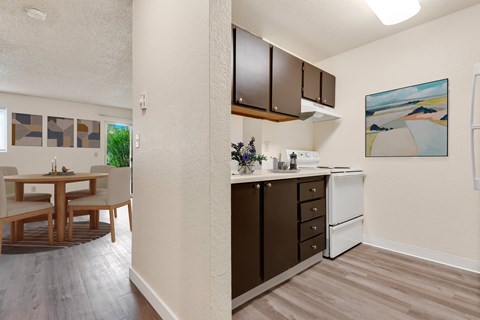 a kitchen and dining room area with a table and chairs and a wall