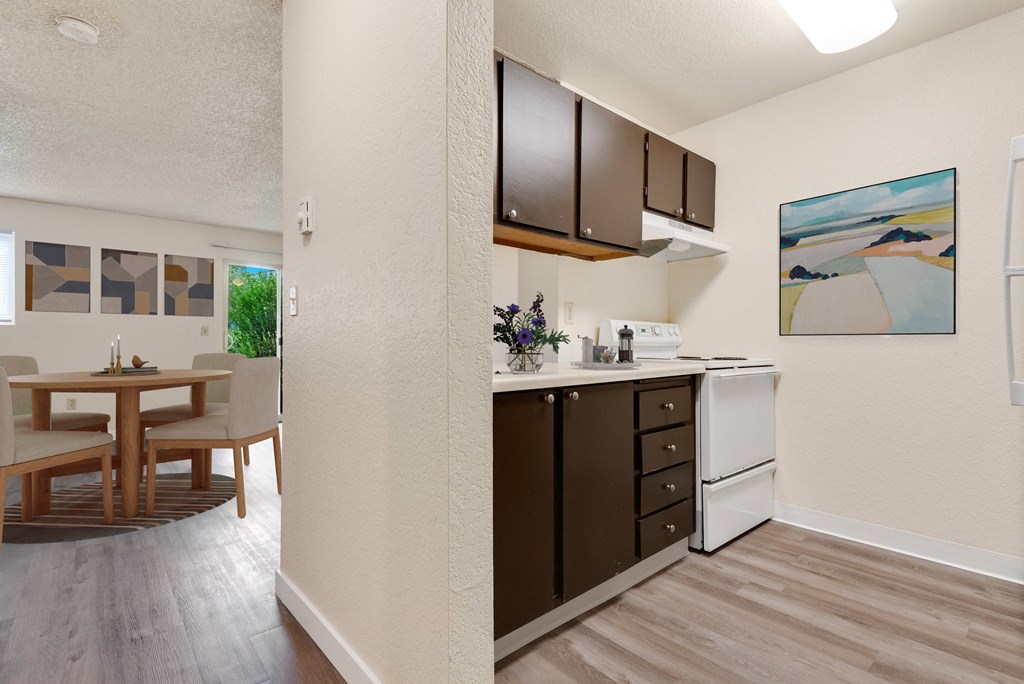 a kitchen and dining room area with a table and chairs and a wall a kitchen and dining room area with a table and chairs and a wall at Eagles Landing Apartments, Washington
