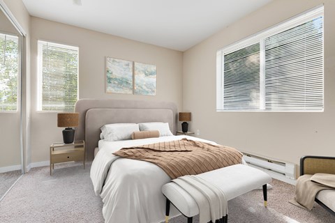 a bedroom with a large bed and two windows at Sage Apartments, Washington