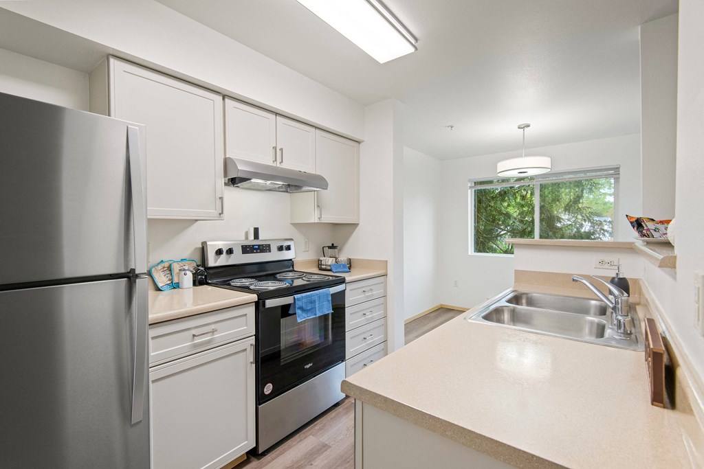 a kitchen with white cabinets and stainless steel appliances