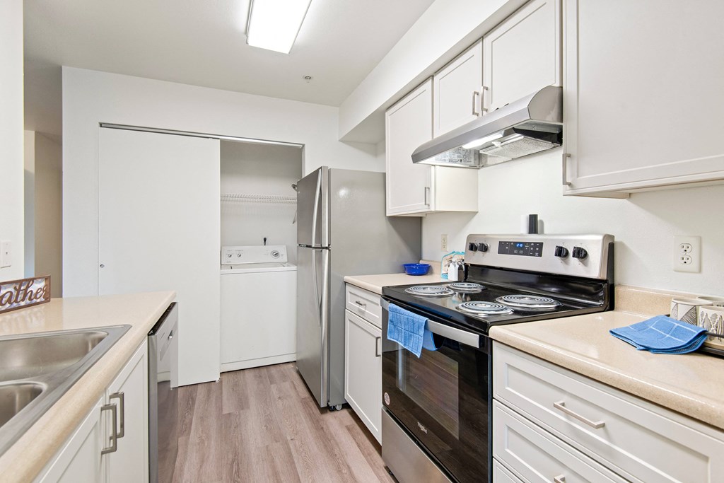 a renovated kitchen with white cabinets and stainless steel appliances