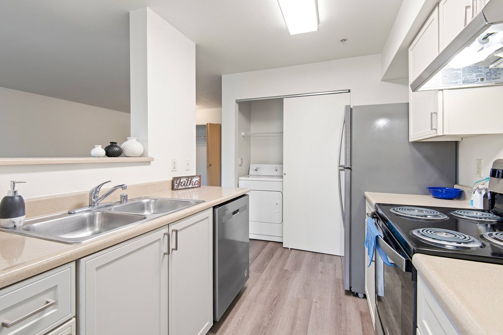 a kitchen with white cabinets and stainless steel appliances