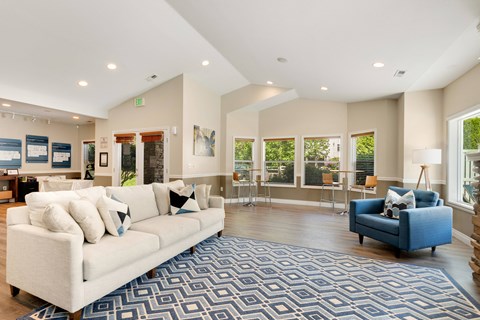 a living room with a white couch and a blue chair at Sage Apartments, Everett, 98204