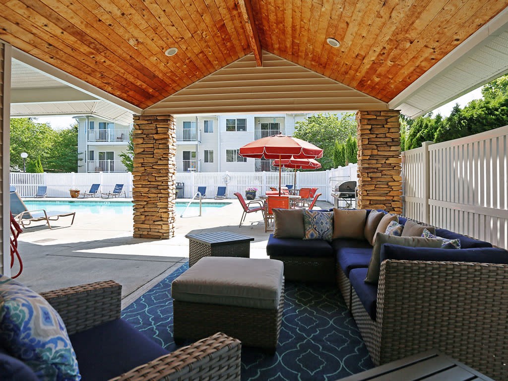 a covered patio with furniture and a pool