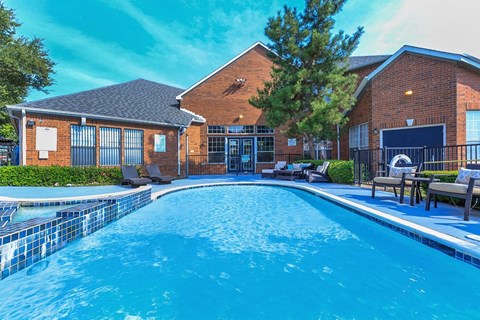 a large swimming pool in front of a brick building