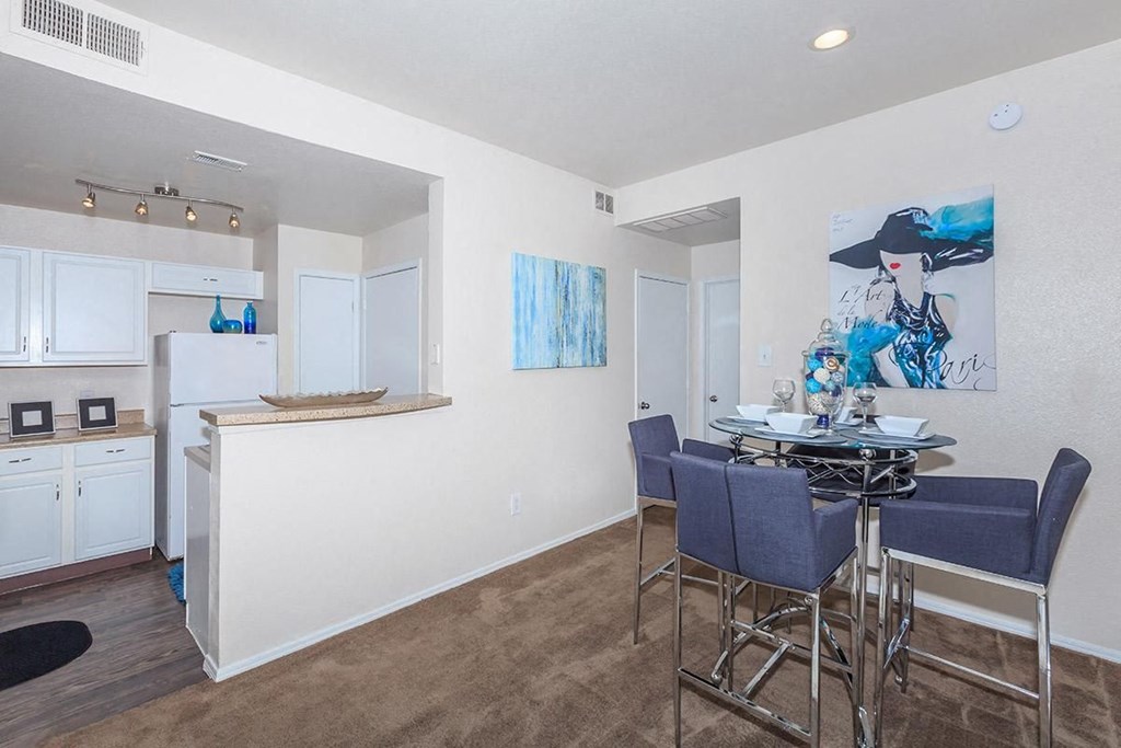 a dining room and kitchen with a table and chairs