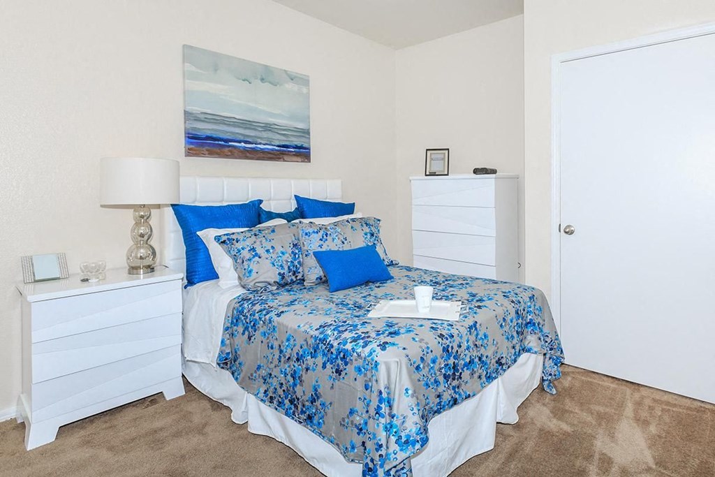 a bedroom with a bed and blue pillows