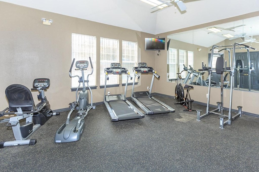 a gym with various exercise equipment on the floor