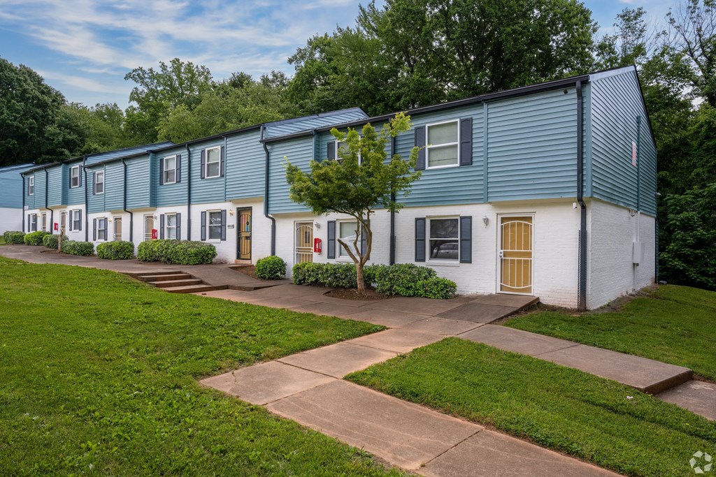a row of houses with blue and white siding and a sidewalk