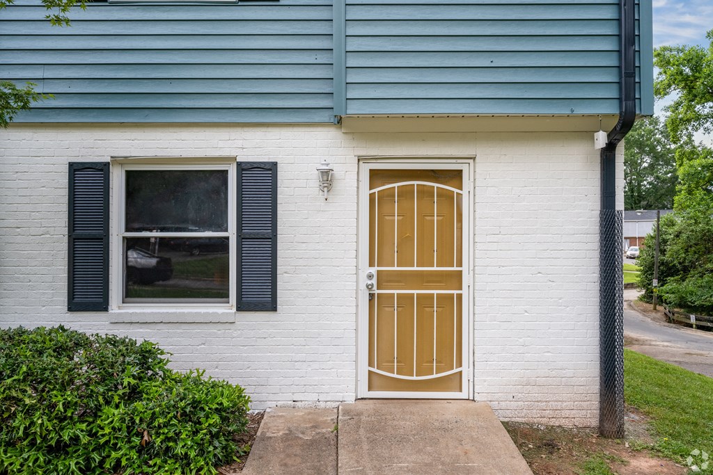 the front door of a white house with a gold door