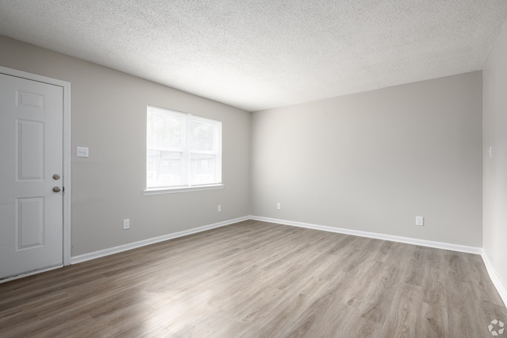 an empty room with wooden floors and a white door