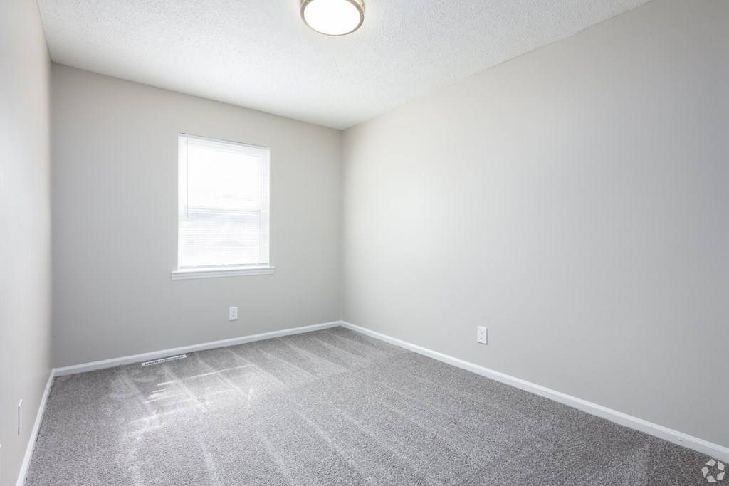 an empty room with white walls and a window