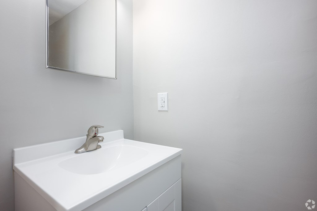 a white bathroom with a sink and a mirror