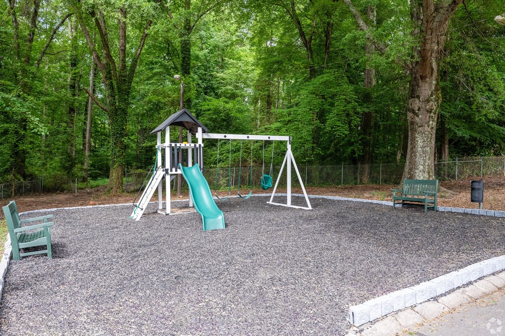 a swing set in a park with a tree