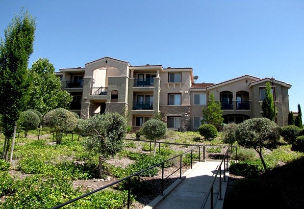 an apartment building with a garden in front of it