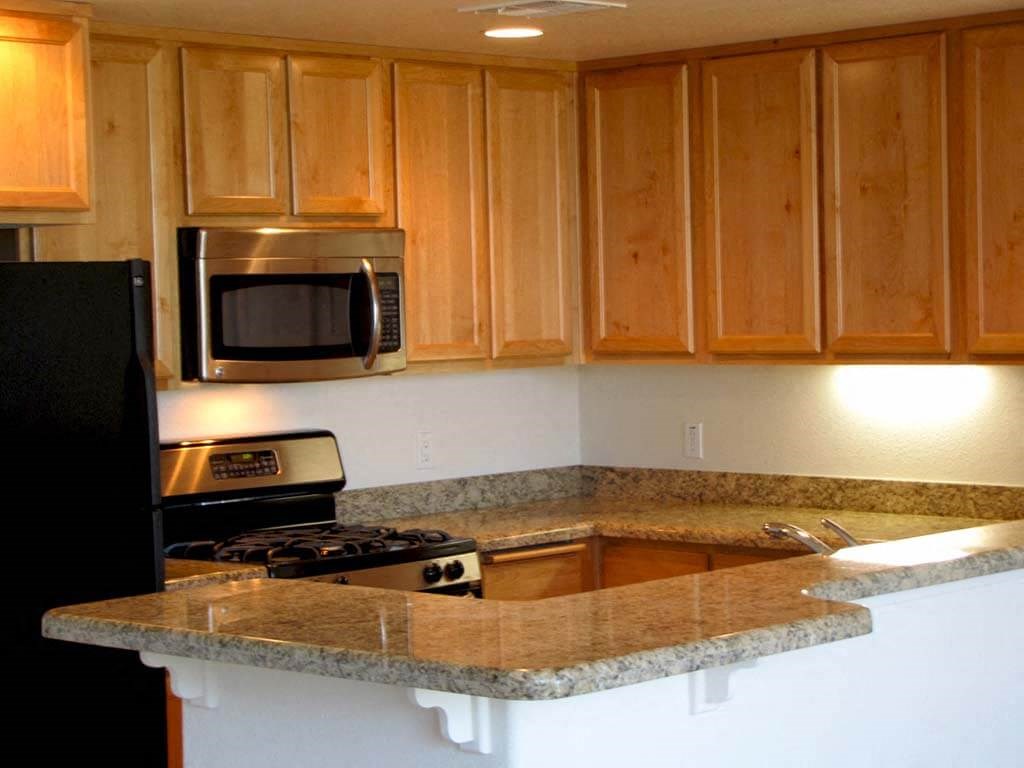 a kitchen with wooden cabinets and a granite counter top