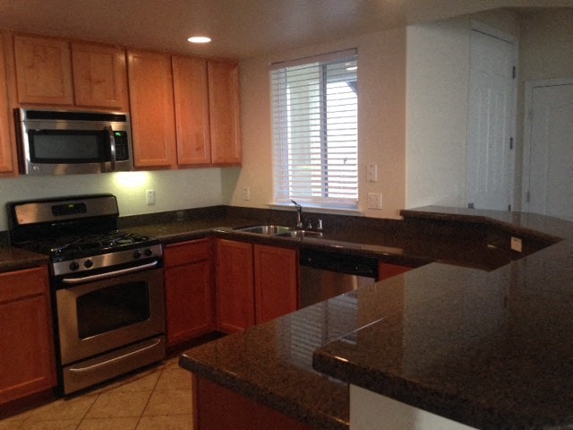 a kitchen with granite counter tops and stainless steel appliances