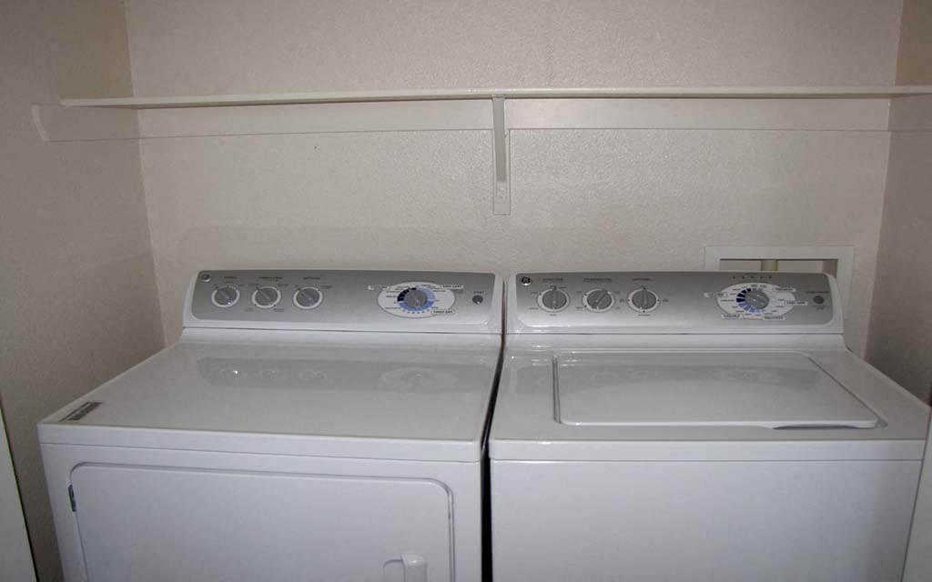 two white washers and dryers in a white room