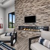 A living room with a stone wall and a fireplace.