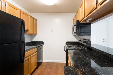 a kitchen with black counter tops and black appliances