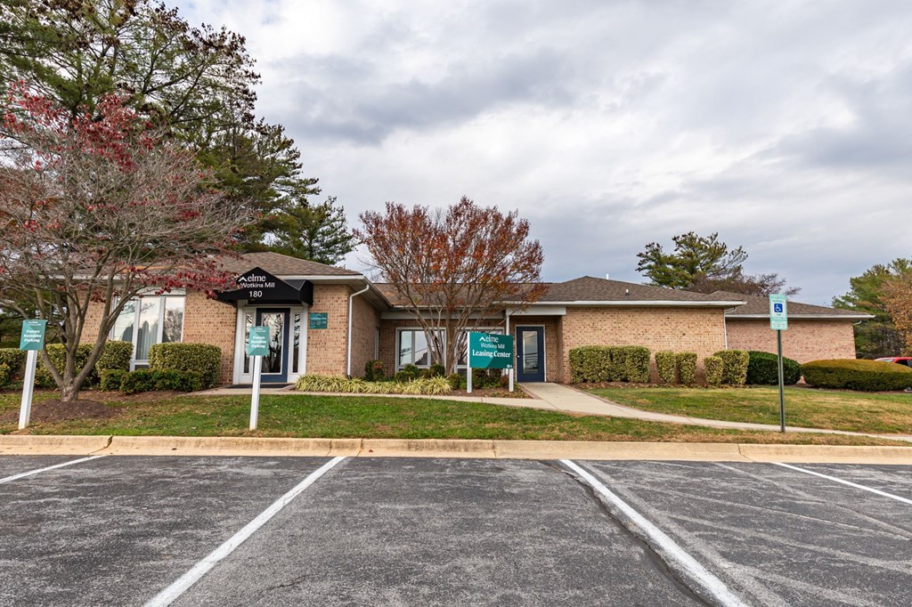 a brick building with a parking lot and trees