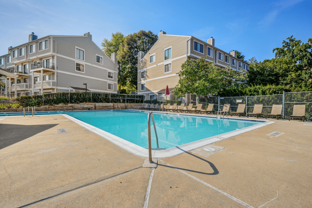 A swimming pool in front of a building with a fence around it  at Elme Bethesda, Bethesda Maryland