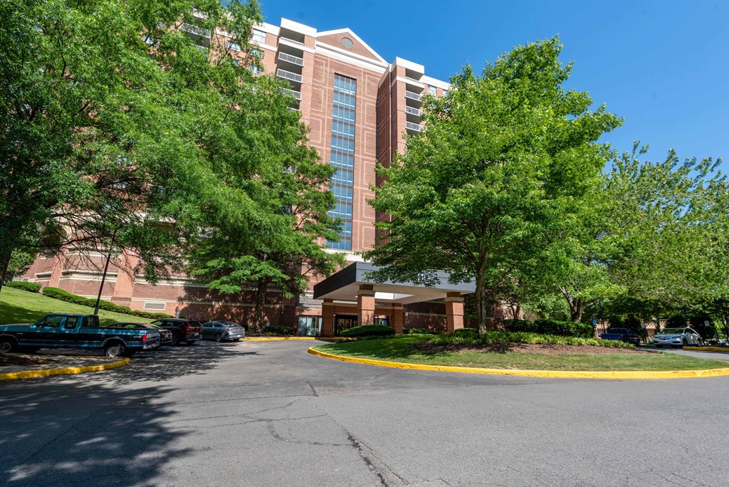 a parking lot with a building in the background and trees