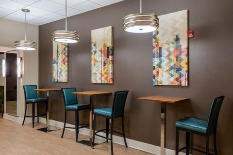 a dining area with tables and chairs and art on the wall at Cascade at Landmark, Virginia