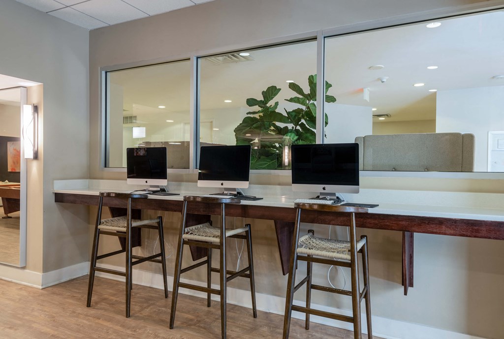 three monitors sit on a counter in front of three stools at Cascade at Landmark, Virginia