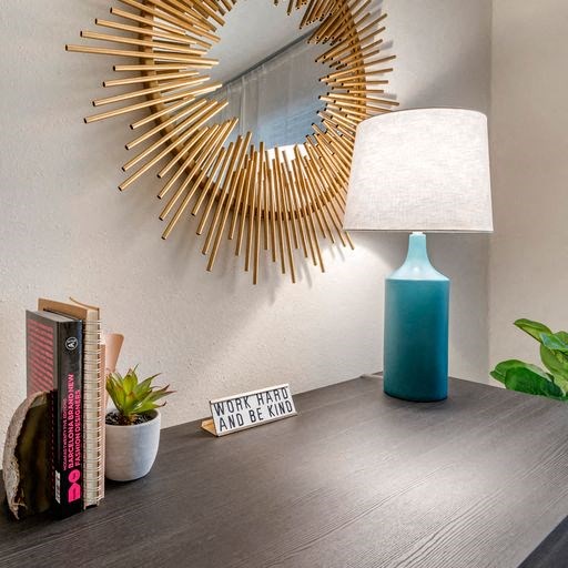 a desk with a lamp and a mirror on the wall at Elme Alexandria, Alexandria Virginia