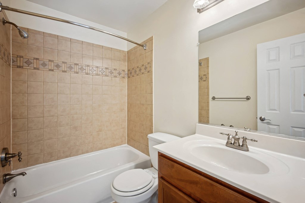 A bathroom with a white tub, toilet, and sink at Elme Bethesda, Bethesda, 20814