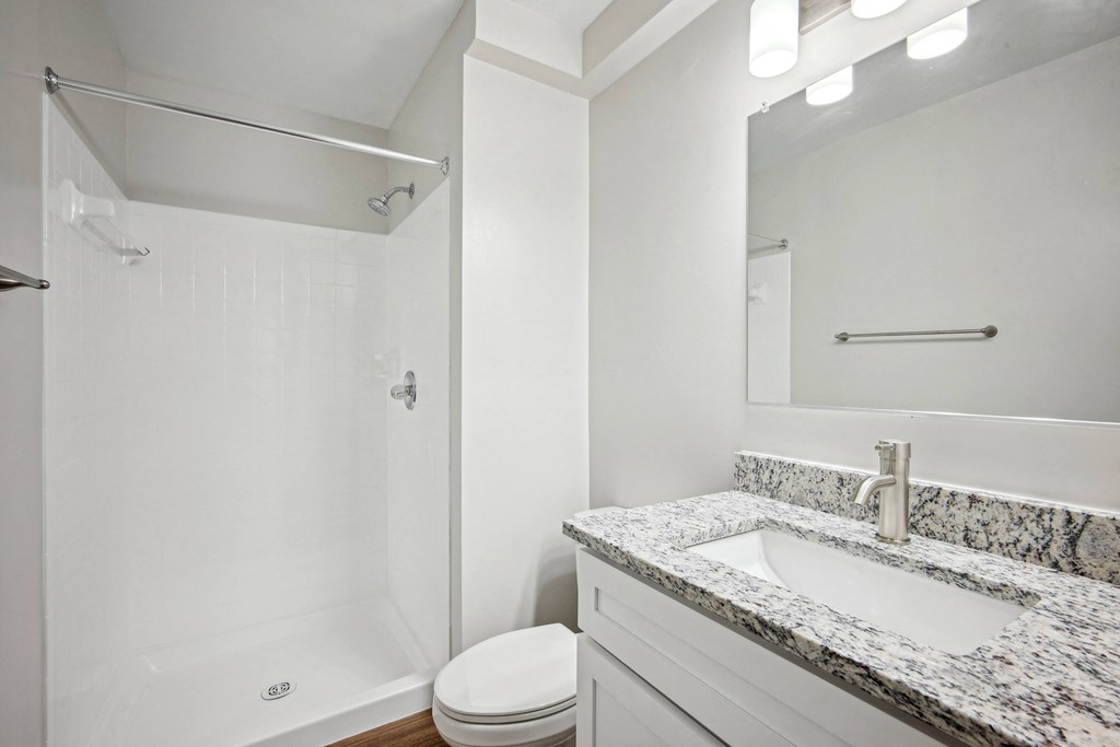 A white bathroom with a marble countertop and a toilet at Elme Bethesda, Bethesda, 20814