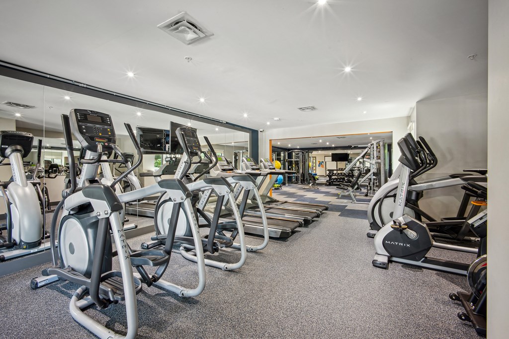 A gym with a variety of exercise equipment including treadmills, stationary bikes, and weight machines at Elme Bethesda, Bethesda, 20814