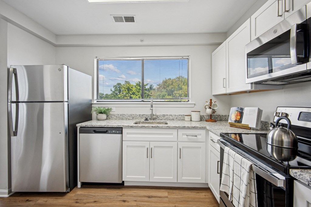 A kitchen with white cabinets and a stainless steel refrigerator at Elme Bethesda, Bethesda, 20814