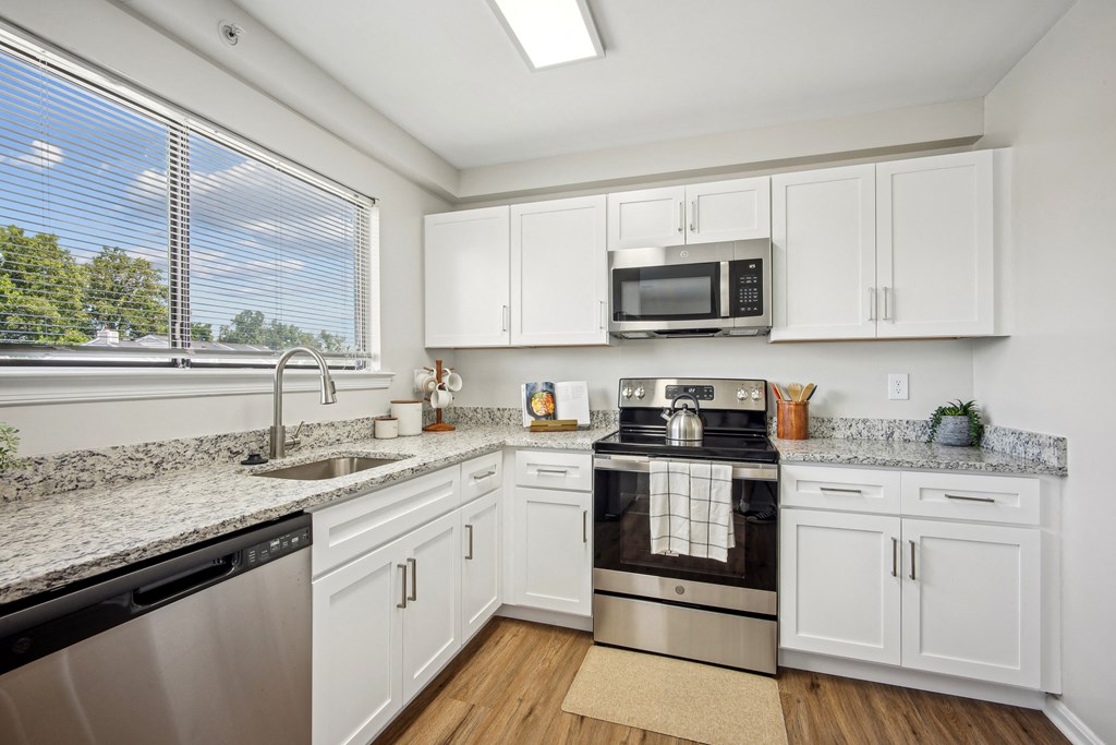 A kitchen with white cabinets and a black stove top oven at Elme Bethesda, Bethesda, 20814