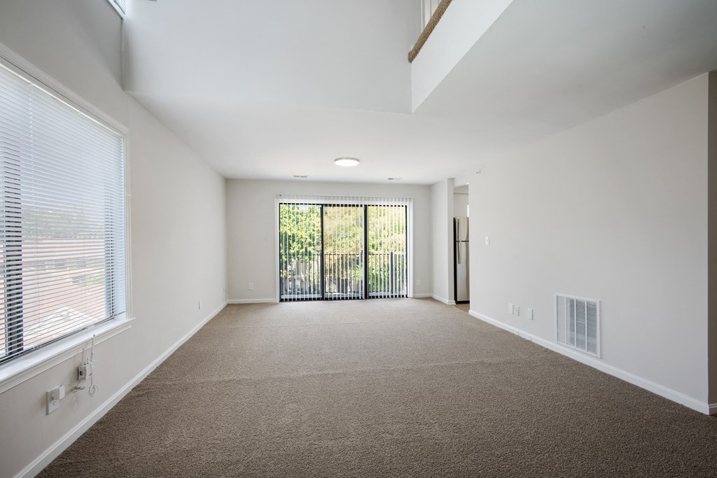 A spacious room with a carpeted floor and a sliding glass door leading to a balcony at Elme Bethesda, Bethesda, 20814