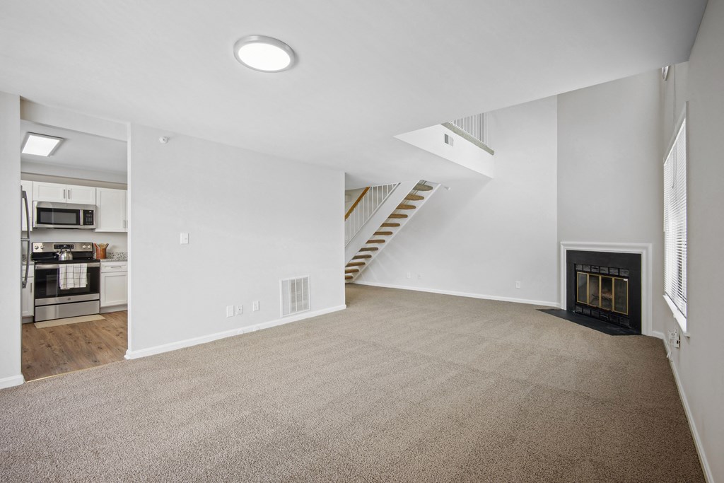 A spacious living room with a fireplace and a staircase at Elme Bethesda, Bethesda, 20814