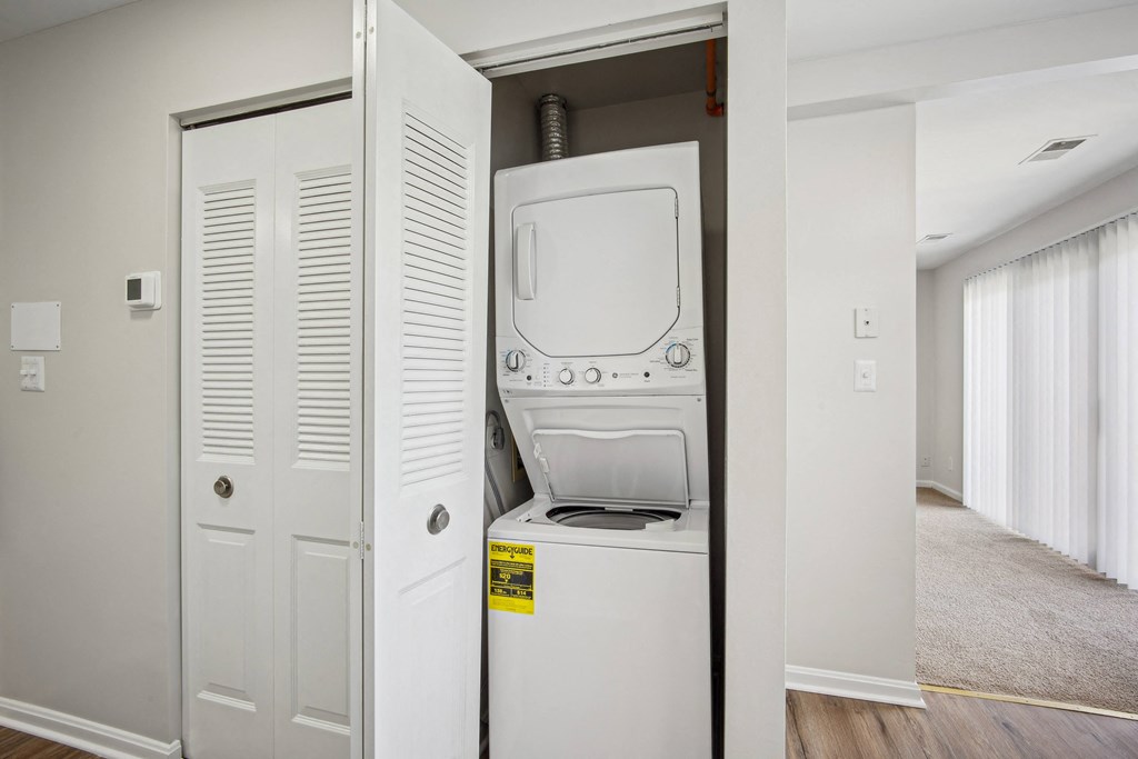 A white washing machine is in a small alcove in a room at Elme Bethesda, Bethesda, 20814