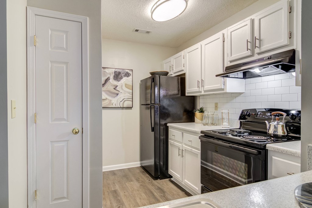 a kitchen with white cabinets and black appliances and a black refrigerator  at Elme Conyers, Georgia, 30013