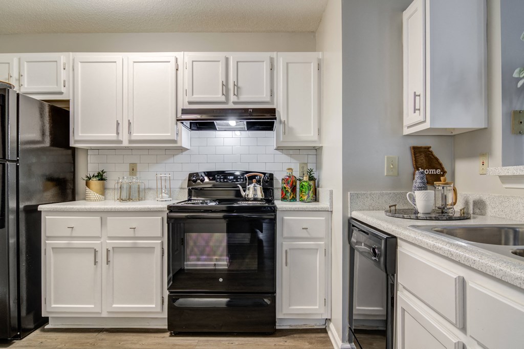 a kitchen with white cabinets and black appliances and a sink  at Elme Conyers, Georgia, 30013
