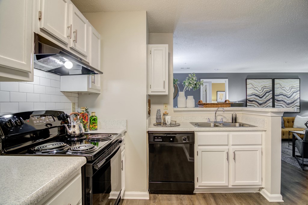 an open kitchen with white cabinets and a stove top oven and a sink  at Elme Conyers, Conyers, GA, 30013