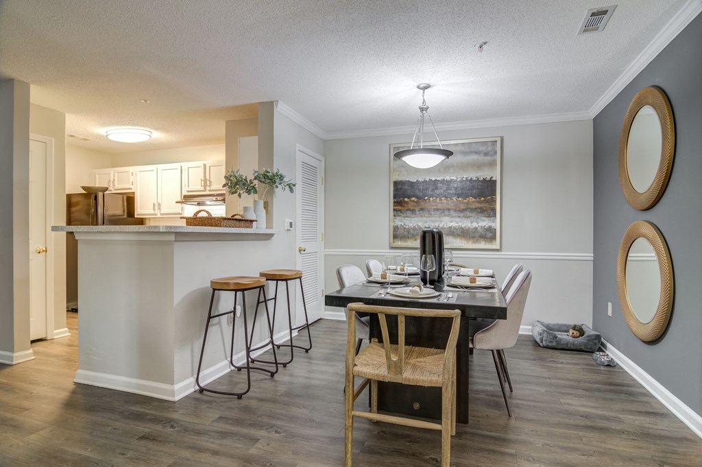 a dining room with a table and chairs and a kitchen with a bar at Elme Conyers, Conyers, 30013