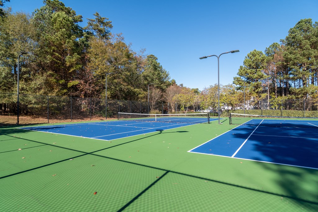 two tennis courts with trees in the background on a sunny day at Elme Conyers, Georgia, 30013