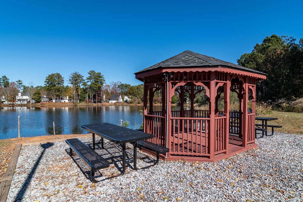 a gazebo with a picnic table next to a lake at Elme Conyers, Conyers, 30013 at Elme Conyers, Conyers, 30013