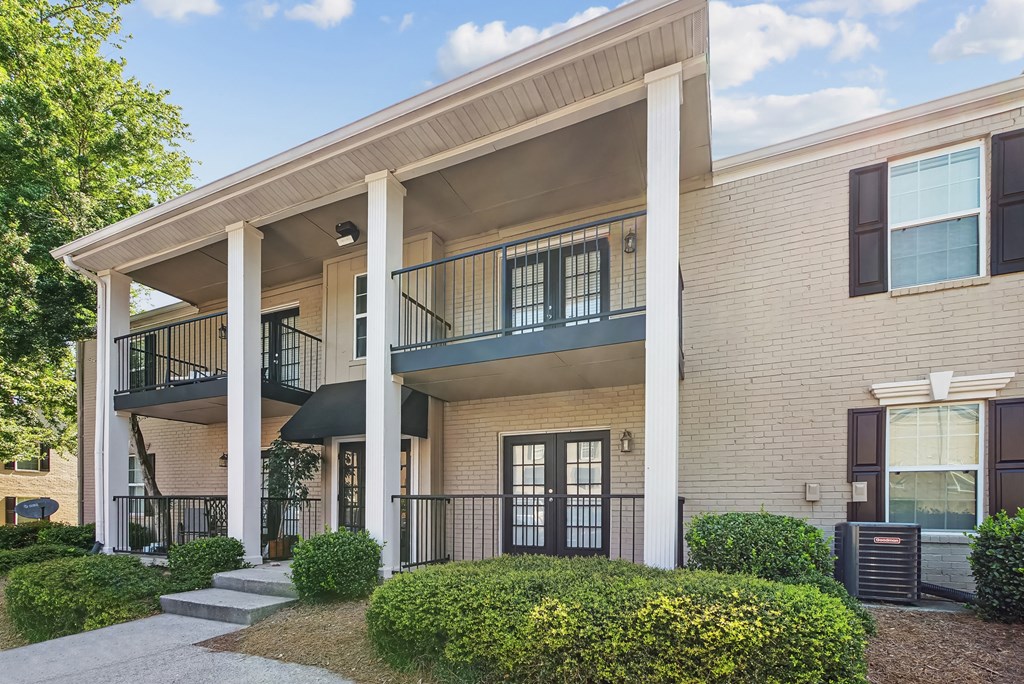 A two-story apartment building with a balcony on the second floor.