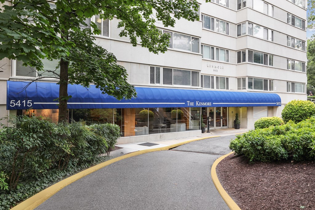 The entrance to The Kenmore apartment building is covered by a blue awning.