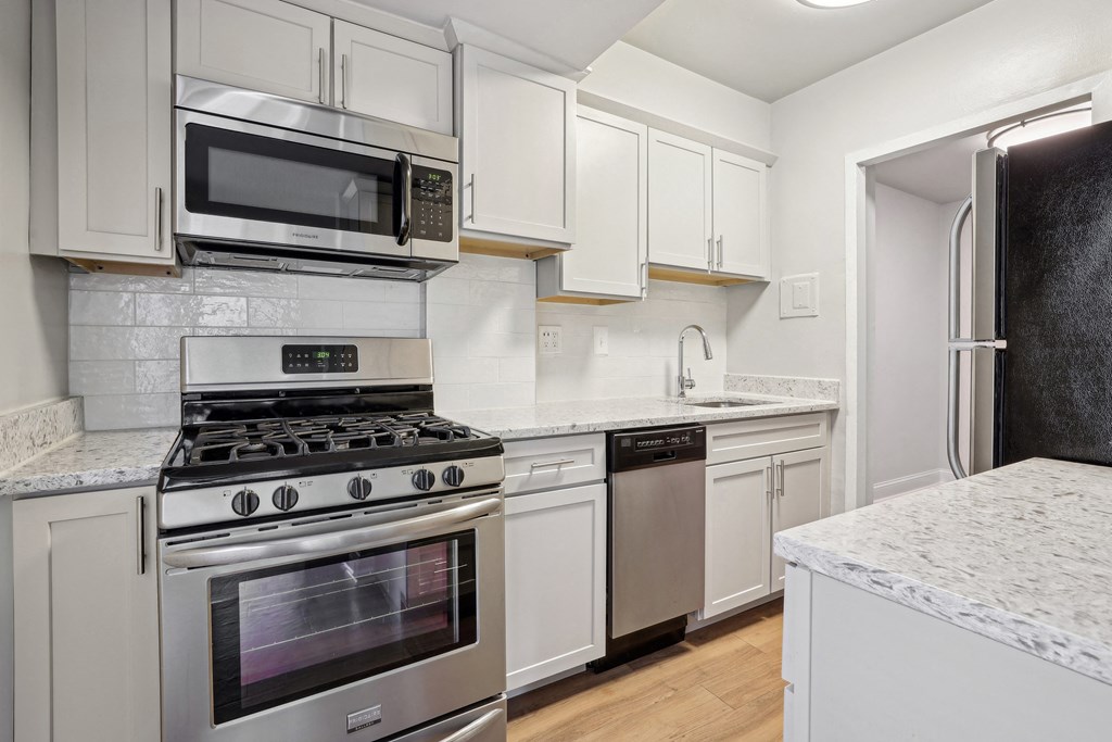 A kitchen with a stove, microwave, and dishwasher at The Kenmore, Washington, 20015